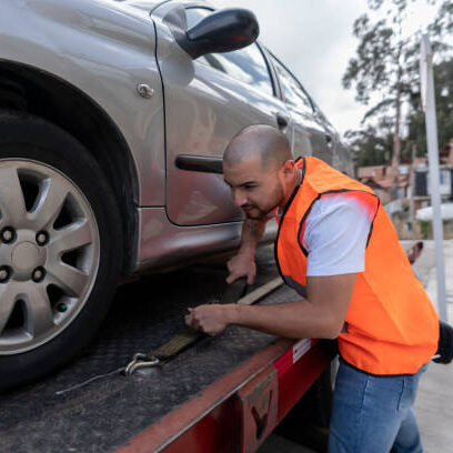 Latin American tow truck operator towing a car - roadside assistance concepts